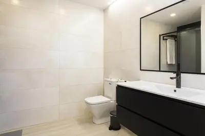 a bathroom with a toilet and a sink and a mirror at SeaVillage Asia - City Center by HD in Vilamoura