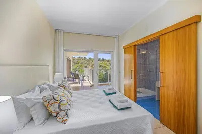 a bedroom with a large white bed and a balcony at Villa Casa Joao by Villa Plus in Albufeira