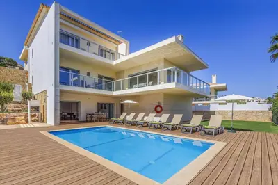 a large house with a swimming pool in front of it at Villa Casa Petunia by Villa Plus in Albufeira