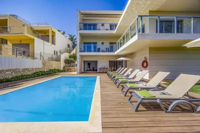 a villa with a swimming pool and lounge chairs at Villa Casa Petunia by Villa Plus in Albufeira