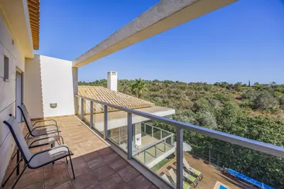 a balcony of a house with two chairs on it at Villa Casa Petunia by Villa Plus in Albufeira