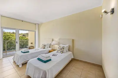 two beds in a room with a window at Villa Casa Petunia by Villa Plus in Albufeira
