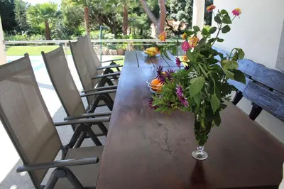 a wooden table with a vase of flowers on it at Villa com piscinas - Quintinha do Lago in Quarteira