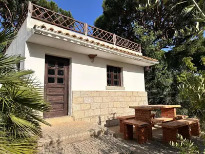 a small house with a picnic table in front of it at Villa com piscinas - Quintinha do Lago in Quarteira