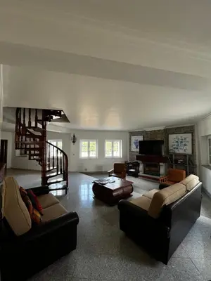 a living room with two couches and a staircase at Villa com piscinas - Quintinha do Lago in Quarteira
