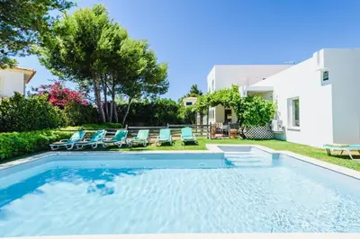 a swimming pool with chairs and a house at Villa 715 - our Albufeira holiday retreat in Albufeira