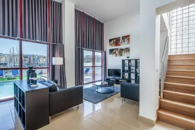 a living room with a staircase and windows at Villa Malibu Marina in Albufeira