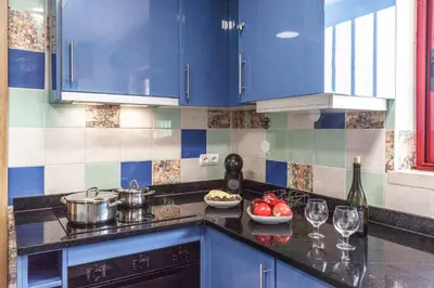 a kitchen with blue cabinets and a counter with wine glasses at Villa Malibu Marina in Albufeira