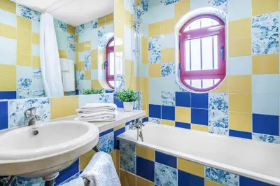 a bathroom with blue and yellow tiled walls and a sink at Villa Malibu Marina in Albufeira