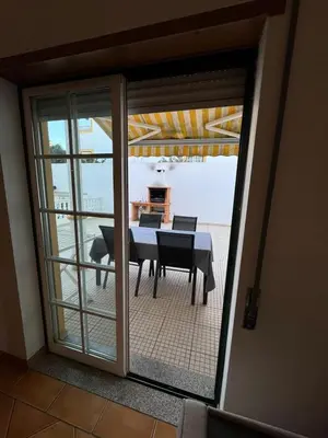 a room with a table and a view of a patio at Casa Vila Sul AE in Roja- Pé