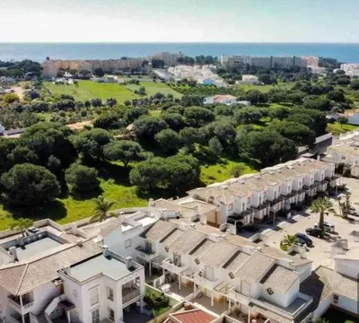 an aerial view of a resort with trees and buildings at Casa Vila Sul AE in Roja- Pé