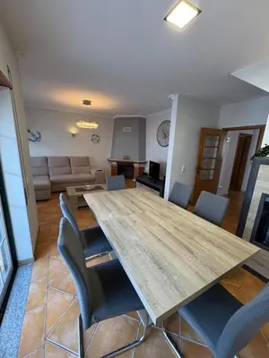 a living room with a large wooden table and chairs at Casa Vila Sul AE in Roja- Pé