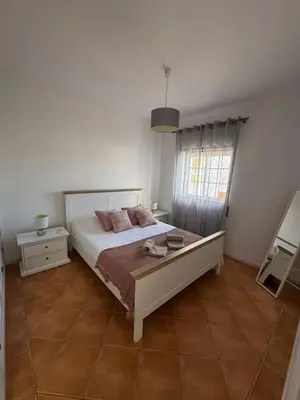 a bedroom with a large bed and a window at Casa Vila Sul AE in Roja- Pé