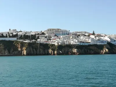 a beach with a bunch of chairs and the ocean at Bay View Albufeira in Albufeira