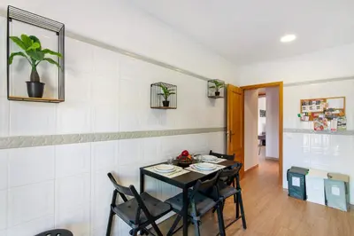 a dining room with a black table and chairs at Cosy Apartment With Pool 2 in Vilamoura