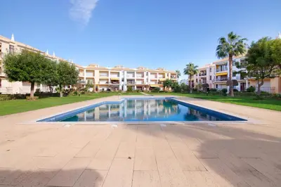 a swimming pool in front of a apartment complex at Cosy Apartment With Pool 2 in Vilamoura