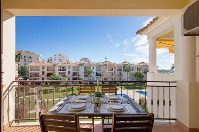 a dining table on a balcony with a view of buildings at Cosy Apartment With Pool 2 in Vilamoura