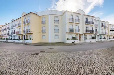 a large white building on the side of a street at Cosy Apartment with Pool 1 in Vilamoura