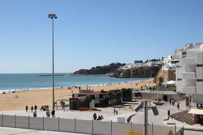 a view of a beach with people and buildings at Paulos Studio in Faro