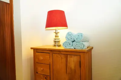 a lamp on top of a wooden dresser with towels at Salgados Apartment in Albufeira
