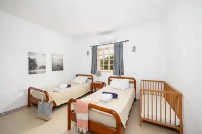 two twin beds in a room with a window at Villa Baltin in Albufeira