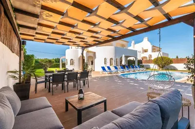 an outdoor patio with a couch and chairs and a table at Villa Baltin in Albufeira