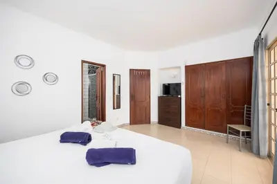 a bedroom with a bed with two purple towels on it at Villa Baltin in Albufeira