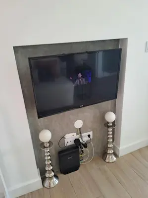 a flat screen tv in a living room with two small lights at Praia da Falésia, O Melhor Estúdio da Aldeia das Acoteias in Albufeira