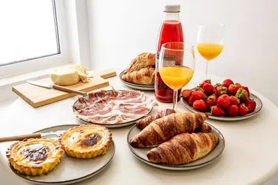 a table with plates of pastries and glasses of wine at Casas das Ilhas in Faro
