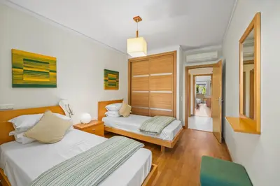 a hotel room with two beds and a chair at Palm Breeze Terrace Vilamoura in Vilamoura