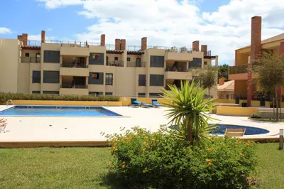 an apartment complex with a swimming pool in front of a building at Palm Breeze Terrace Vilamoura in Vilamoura