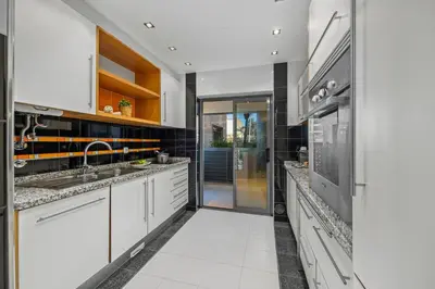 a kitchen with white cabinets and a sink at Palm Breeze Terrace Vilamoura in Vilamoura