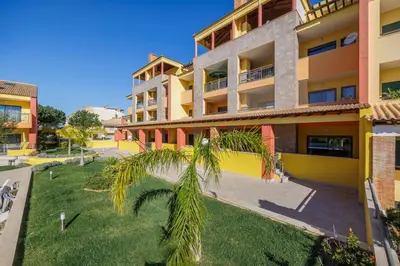 a palm tree in front of a building at Palm Breeze Terrace Vilamoura in Vilamoura