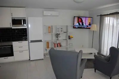 a kitchen with a table and chairs and a tv on the wall at Holiday home in Santa Barbara de Nexe - Algarve 51807 in Santa Bárbara de Nexe