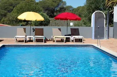 a pool with two umbrellas and chairs and a table and chairs at Holiday home in Santa Barbara de Nexe - Algarve 51807 in Santa Bárbara de Nexe
