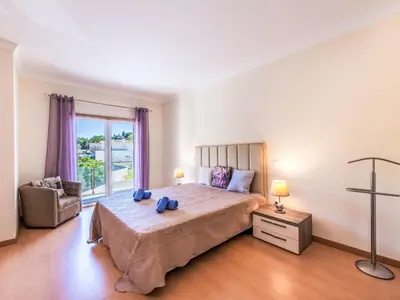 a bedroom with a bed and a chair and a window at Holiday Home Vila Parra by Interhome in Galé