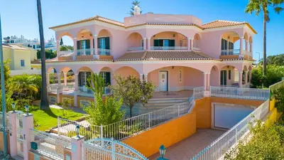 a pink house with a white fence at Villa Agadir by Algarve Vacation in Albufeira