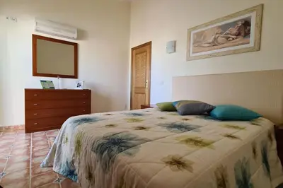a bedroom with a bed with two pillows and a dresser at Vila Rafaella - Praia de São Rafael in Sesmarias