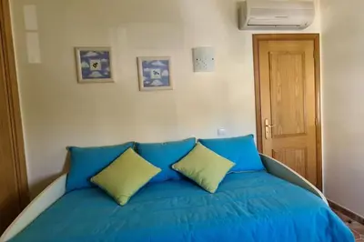 a blue bed with two pillows in a room at Vila Rafaella - Praia de São Rafael in Sesmarias
