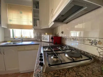 a kitchen with a stove and a counter top at Vila Rafaella - Praia de São Rafael in Sesmarias