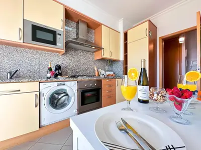 a kitchen with a washing machine and wine glasses on a counter at Sea View Apartment by Be Cherish in Albufeira