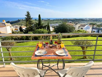 a table with chairs and wine glasses on a balcony at Sea View Apartment by Be Cherish in Albufeira