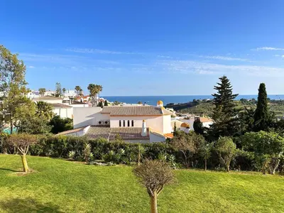 a white house on top of a green field at Sea View Apartment by Be Cherish in Albufeira