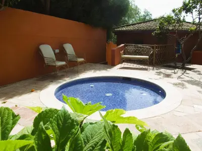 a swimming pool in a yard with two chairs at Quinta dos Amigos in Almancil