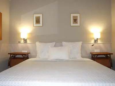 a bedroom with a large white bed with two lamps at Quinta dos Amigos in Almancil