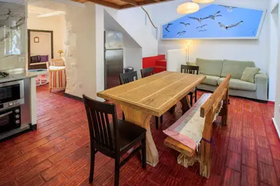 a kitchen and dining room with a wooden table and chairs at Quinta dos Amigos in Almancil