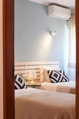 a room with two beds and a table with a lamp at Casas Barulho Apartment Old Town in Albufeira