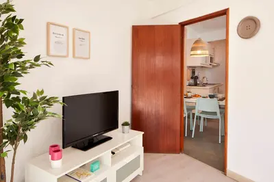 a living room with a television on a white cabinet at Casas Barulho Apartment Old Town in Albufeira