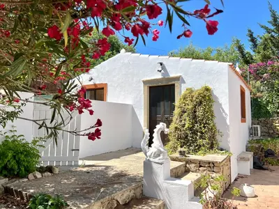 a white house with a statue in front of it at Casa de Limoeiro - Countryside Villa in Córregos de Santa Luzia
