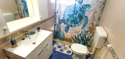 a bathroom with a turtle shower curtain and a toilet at Apartamento Perto da Praia Albufeira in Albufeira